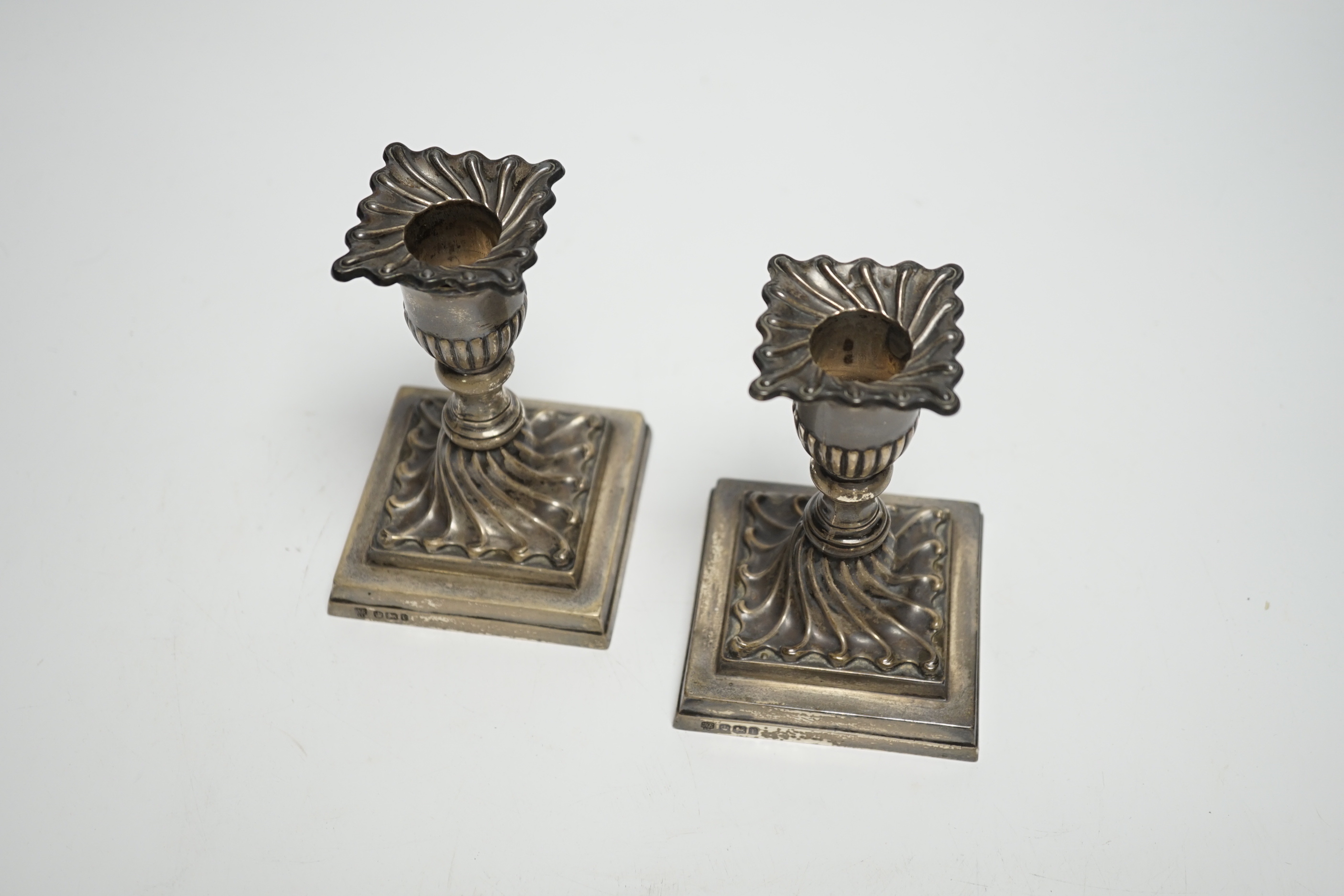 A pair of late Victorian wrythened silver mounted dwarf candlesticks, Hawksworth, Eyre & Co Ltd, Sheffield, 1897, 11.1cm, weighted.